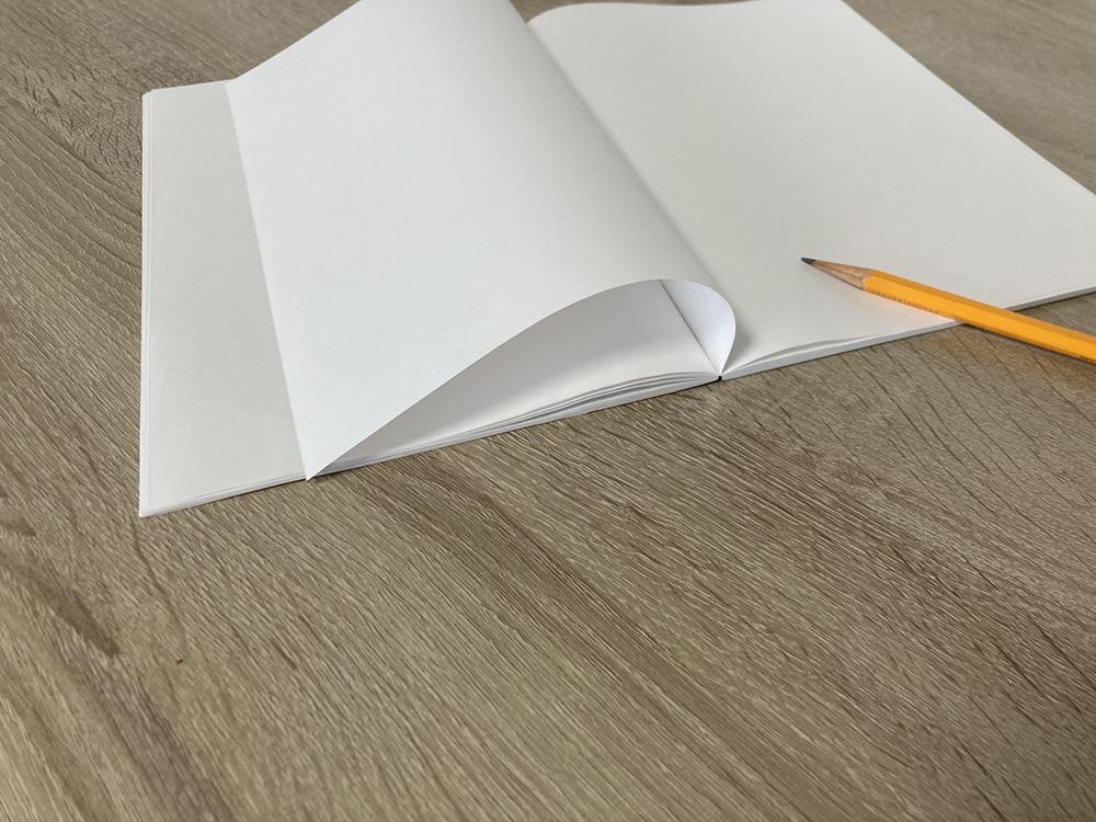 机上にノートと鉛筆が転がっている様子