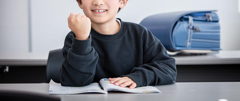 塾の席で勉強する小学生